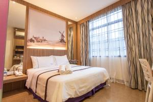 a bedroom with a bed with two towels on it at Lavender Inn Nusa Bestari in Johor Bahru