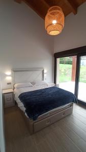 a bedroom with a large bed with a large window at La finca del Goño in Pravia