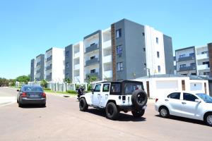 Ein Jeep parkt auf einem Parkplatz neben Autos in der Unterkunft Soldout Camp 1 in Johannesburg