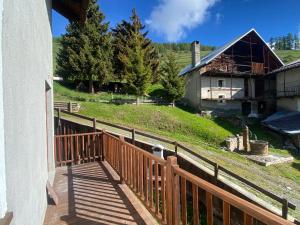 einen Balkon mit einem Holzzaun und einem Haus in der Unterkunft Locanda Allevè Hotel Ristorante in Pragelato