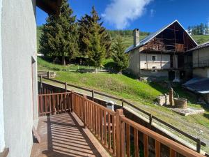 balkon z drewnianym płotem i domem w obiekcie Locanda Allevè Hotel Ristorante w mieście Pragelato