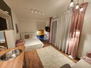 ein Bad mit einem Waschbecken und ein Bett in einem Zimmer in der Unterkunft Apartman 18 in Debrecen