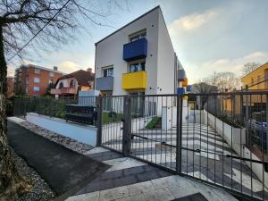 ein kleines weißes Haus mit einem schwarzen Zaun in der Unterkunft Apartman 18 in Debrecen