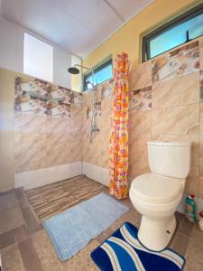 a bathroom with a toilet and a shower at La Rosedepine chez Mariani chez l'habitant in Rodrigues Island