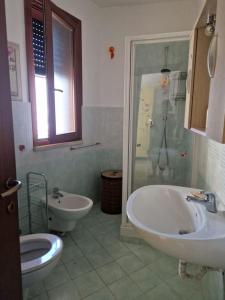 een badkamer met 2 wastafels, een douche en een toilet bij Affitto bilocale Pomezia in Pomezia