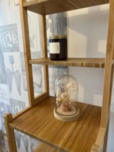 a wooden shelf with a glass jar with a plant in it at 3-Bedroom Apartment In The Heart of London in London