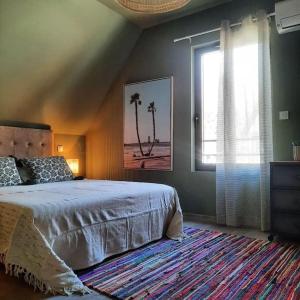 ein Schlafzimmer mit einem Bett und einem Fenster mit Palmen in der Unterkunft Le Vertigo proche centre histo avec 2 parkings in Sarlat-la-Canéda