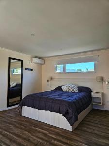 1 dormitorio con cama y ventana grande en Complejo Altos La Caleta en Mar de Cobo