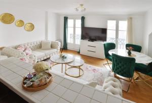 a living room with a couch and a table at L'Amandier Disneyland JO Paris 2024 pour 4 personnes et 1 bébé in Bailly-Romainvilliers