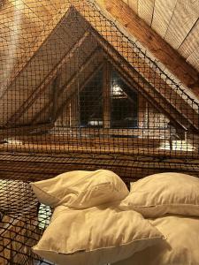 a bird cage with two pillows and a window at Humno in Nová Baňa