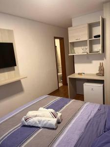 1 dormitorio con 1 cama con toallas en Flat - Suíte Trocadéro - 112, en Lagoa Santa