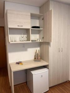 a room with a desk and a shelf with vases at Flat - Suíte Trocadéro - 112 in Lagoa Santa