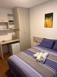 ein Schlafzimmer mit einem Bett mit Handtüchern darauf in der Unterkunft Flat - Suíte Trocadéro - 112 in Lagoa Santa