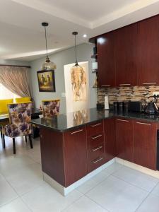 a kitchen with wooden cabinets and a counter top at Gardens Villa in Nelspruit