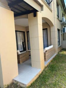 a porch of a house with wicker chairs at Gardens Villa in Nelspruit