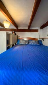 Una gran cama azul en una habitación con techo en Casa Peggy, en Cádiar