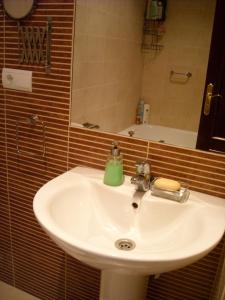 lavabo blanco en el baño con espejo en Apartamento centro historico, en Écija