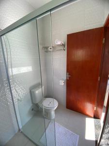 a bathroom with a toilet and a glass shower at Chalé Estância da Pinha seu Refúgio na Montanha in Santo Antônio do Pinhal