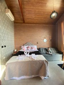 a child sitting on a bed in a bedroom at Chalé Estância da Pinha seu Refúgio na Montanha in Santo Antônio do Pinhal