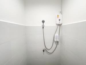 a shower in a white tiled bathroom at TRANSIT Donmueang Airport HOSTEL in Thung Si Kan