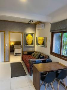 a living room with a bed and a table and chairs at BeMyGuest Floripa in Florianópolis