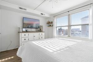 a white bedroom with a bed and a large window at Ocean Block Condo 100 Steps From the Beach in Ocean City