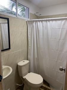 ein Bad mit einem WC, einem Waschbecken und einem Fenster in der Unterkunft Hotel Playarena in Coveñas