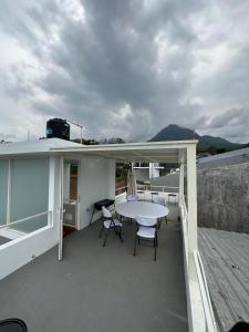 eine Terrasse mit einem Tisch und Stühlen auf dem Dach in der Unterkunft Villa Jasmine Batu in Batu