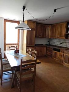 cocina con mesa y sillas y comedor en Spazioso appartamento Nico, en Dimaro