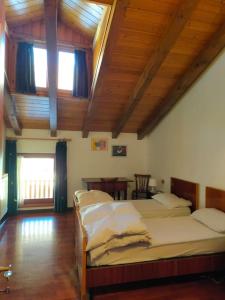 a bedroom with two beds and a wooden ceiling at Spazioso appartamento Nico in Dimaro