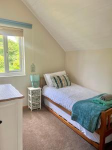 a small bedroom with a bed and a window at Medway Lodge in South Cerney