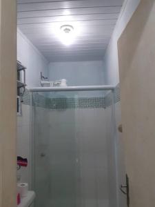 a white bathroom with a shower and a sink at Studio Praia Barra de Guaratiba in Rio de Janeiro