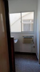 a bathroom with a window and a toilet in a room at Studio Praia Barra de Guaratiba in Rio de Janeiro
