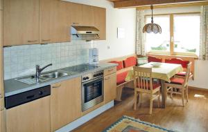 ペットイ・アム・アールベルクにあるNice Apartment In Pettneu Am Arlberg With 2 Bedrooms And Wifiのキッチン(シンク、ダイニングルームとテーブル付)