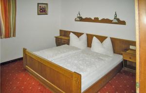 ペットイ・アム・アールベルクにあるNice Apartment In Pettneu Am Arlberg With 2 Bedrooms And Wifiのベッドルーム1室(白い枕の木製ベッド1台付)