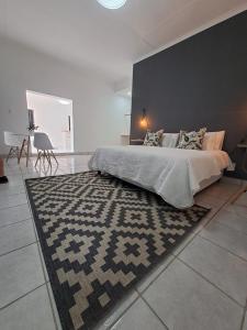 um quarto com uma cama grande e um tapete em 2 On Greeff em Graaff-Reinet