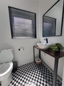 uma casa de banho com um WC, um lavatório e um espelho. em 2 On Greeff em Graaff-Reinet