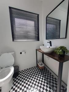 a bathroom with a toilet and a sink and a mirror at 2 On Greeff in Graaff-Reinet +1 photo