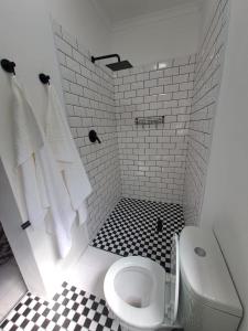 uma casa de banho com WC e piso em azulejo preto e branco em 2 On Greeff em Graaff-Reinet