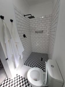 a bathroom with a toilet and a black and white tile floor at 2 On Greeff in Graaff-Reinet