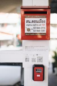 a red box is on top of a machine at TRANSIT Donmueang Airport HOSTEL in Thung Si Kan
