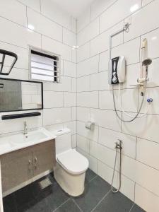 a white bathroom with a toilet and a shower at Sakura 1 Homestay Kampar Landed in Kampar