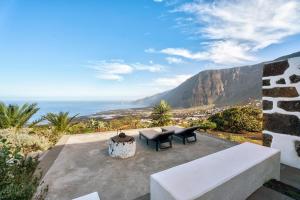a patio with a table and chairs and the ocean at El Lagar in Frontera