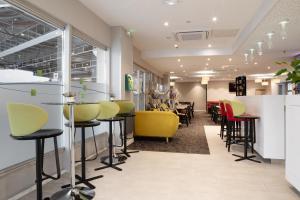 un salon de coiffure avec des chaises jaunes et rouges dans l'établissement Holiday Inn Express Amiens, an IHG Hotel, à Amiens