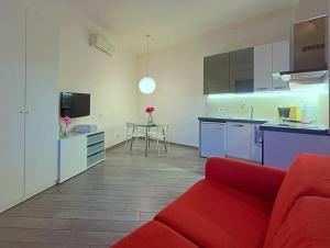sala de estar con sofá rojo y cocina en Appartme Sarca 59, en Milán