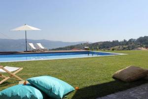 two pillows on the grass next to a swimming pool at Casas da Li in Arcos de Valdevez