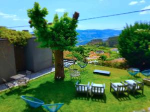 a garden with chairs and a tree with a view at Casas da Li in Arcos de Valdevez
