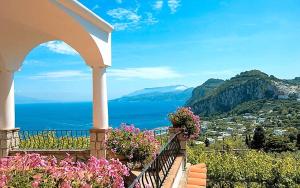 a balcony with flowers and a view of the ocean at Aiano Bed&Breakfast in Capri