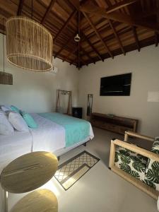 a bedroom with a bed and a tv and a table at La Bella Suítes in Ilhabela
