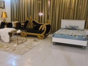 a bedroom with a bed and a couch and a table at بيت الياسمين2 in Al Madinah